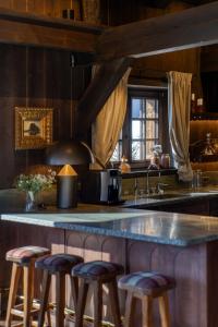 a kitchen with a large counter with stools around it at Chalet de Luxe Saint Gervais avec Vue ,Spa, Jacuzzi, Salle de sport in Saint-Gervais-les-Bains