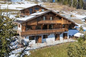 une grande maison en bois avec de la neige sur le toit dans l'établissement Chalet de Luxe 5 chambres Vue MontBlanc ,Spa, Jacuzzi, Salle de sport, à Saint-Gervais-les-Bains