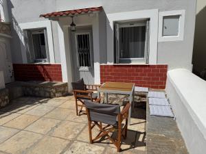 a patio with two chairs and a table in front of a house at MantasHouse in Spetses