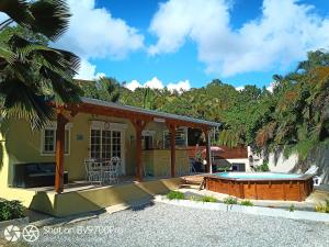 a house with a patio and a hot tub at Wakerasuites in Les Abymes