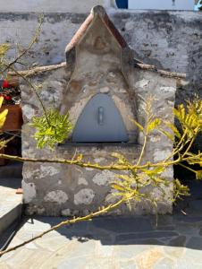 a bird house with a door on a stone wall at MantasHouse in Spetses +37 photos