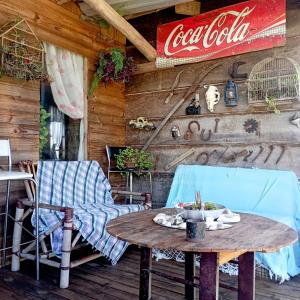 un tavolo e sedie su un portico con un cartello di cocacola di CASA Vida a São Francisco do Sul