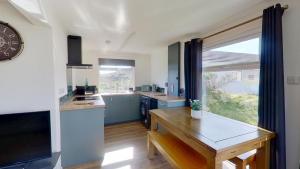 a kitchen with a table and a clock on the wall at G17 St Meva, Riviere Towans in Hayle