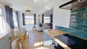 a kitchen and living room with a table and a couch at G17 St Meva, Riviere Towans in Hayle +13 photos