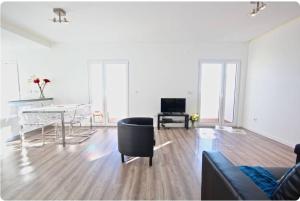 a white living room with a table and a couch at Bright by the Beach - by CoH in Cruz Quebrada