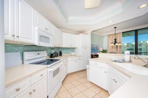 a kitchen with white cabinets and white appliances at Phoenix on the Bay 1427 condo in Orange Beach