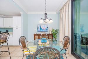 a dining room with a glass table and chairs at Phoenix on the Bay 1427 condo in Orange Beach