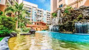 a swimming pool with a waterfall in a building at แอตแลนติส by KT in Jomtien Beach