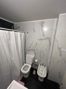 a white bathroom with a toilet and a sink at Studio con amenities zona Hospital Italiamo 6 in Buenos Aires