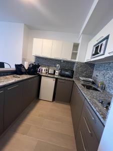 a kitchen with black and white counter tops and appliances at Studio con amenities zona Hospital Italiamo 6 in Buenos Aires