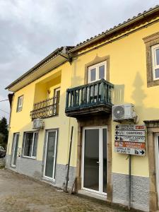 a yellow building with a balcony on top of it at Casa Pinheiro in Pinheiro de Coja