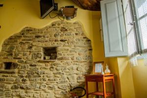a stone wall with a television on top of it at Casa Vacanze Menta&Rosmarino in Mercatello sul Metauro