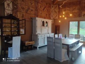 a kitchen with a wooden table and a white cabinet at Le Chat Blanc in Versols-et-Lapeyre