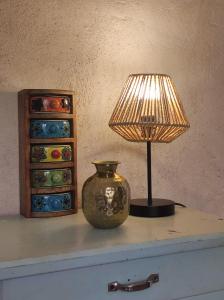 a lamp sitting on a table next to a vase at Petite longère du Clos Madeleine in Vincelles