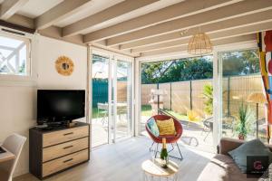 a living room with a couch and a television at Maison de vacances à Biscarrosse lac pour 6 personnes in Biscarrosse