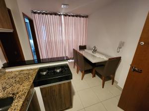 a kitchen and dining room with a stove and a table at 4º Città Residence - Piscina e academia in Brasília