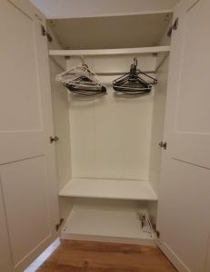 a walk in closet with white shelves and shoes at Ferienwohnung in einer idyllischen Lage in Bremerhaven +1 photo