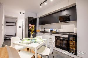 a kitchen with a white table and white chairs at FullView Studio DeLuxe, PLUS Free Underground Parking in Timişoara