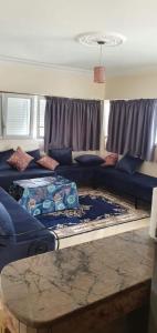 un soggiorno con un divano blu e un tavolo di appartement agadir boulvard hassan ad Agadir