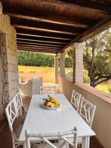 a table and chairs on a porch with a bowl of fruit at Over The Sea Punta Lada in Porto Rotondo
