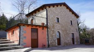 a stone building with a balcony on top of it at Villa Filìa - La Villa dell'Amicizia in Roccamorice