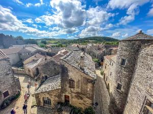 a group of people walking in a village with buildings at Le Chat Blanc in Versols-et-Lapeyre