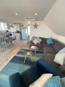 una sala de estar con un sofá y una mesa en By the beach, with sea views and spectacular sunsets, en Westward Ho