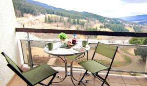 a table and chairs on a balcony with a view at Appartement cosy cœur de station in Villard-de-Lans