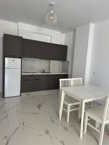 cocina con mesa blanca y nevera blanca en J&P Apartments Saranda, en Sarandë 12 fotos más