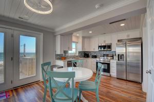 - une cuisine avec une table et des chaises blanches dans l'établissement Sea Biscuit, à Surf City