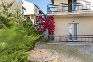 a courtyard of a building with pink flowers at BOHOTEL Eleonas Anex Apartments in Kavos +33 photos