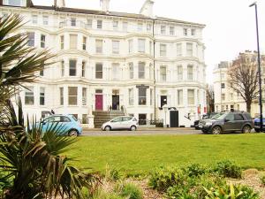a large white building with cars parked in front of it at The Ellesmere Hotel Eastbourne in Eastbourne