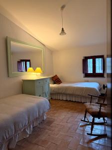 Un dormitorio con dos camas y un espejo y una silla. en Can Silvestre, en Riudarenes 17 fotos más