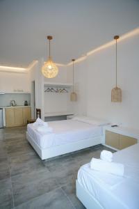 two beds in a room with white walls at Casa di Flora in Loutra