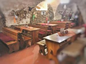 a room with wooden tables and benches in a building at Penzion Pegas Depoltovice in Nová Role