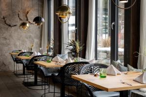 restauracja z drewnianymi stołami i krzesłami oraz oknem w obiekcie Hotel Der Löwe LEBE FREI w mieście Leogang
