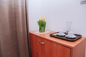 a wooden cabinet with a vase of flowers on it at BASSO Guest Rooms in Perushtitsa