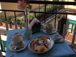 a table with plates of food and cups on a balcony at Residenza Guarna in Salerno