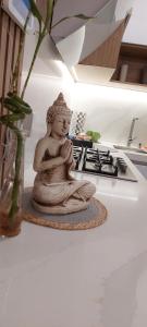 a statue of a woman sitting on a counter next to a stove at departamento boutique centrico- villa carlos paz in Villa Carlos Paz