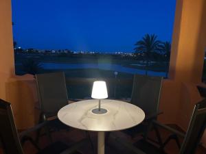 a white table with chairs and a lamp on it at Casa Matthis in Los Alcázares