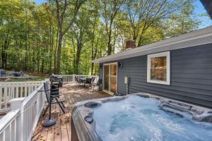 Un jacuzzi en una terraza junto a una casa. en Lakeside, Dock, Hot Tub, Kayaks, Arcade, Playset, en Lake Ariel