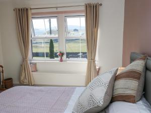 een slaapkamer met een bed en een groot raam bij Kirk Yett Cottage in Skipton