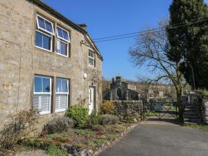 een oud stenen huis met een poort op de achtergrond bij Kirk Yett Cottage in Skipton