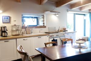 a kitchen with a wooden table and a dining room at Les Groseilliers in Moyrazès