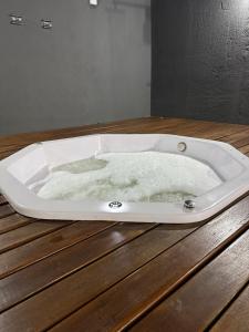 a bath tub filled with water on top of a wooden table at Casa em São João del Rei in São João del Rei