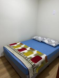 a bed with a quilt on it in a room at Casa em São João del Rei in São João del Rei