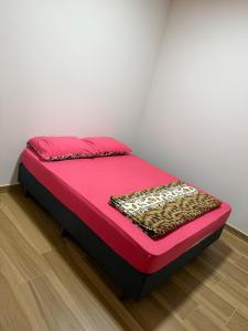 a bed in a room with a pink bedvisor at Casa em São João del Rei in São João del Rei