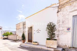 un edificio bianco con delle piante di fronte di Na Chicca - B&B a Melendugno