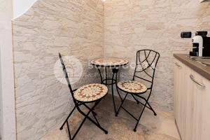 2 sedie e un tavolino in cucina di Na Chicca - B&B a Melendugno