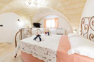 una camera da letto con un letto con due bambole sopra di Na Chicca - B&B a Melendugno